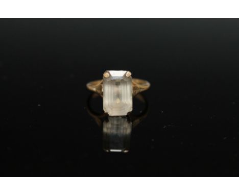 A 9CT YELLOW GOLD DRESS RING, set with an emerald cut opaque stone, ring size R 