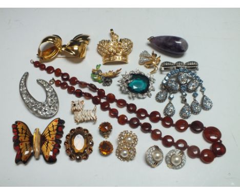 A COLLECTION OF VINTAGE AND MODERN COSTUME JEWELLERY, comprising mostly brooches, together with a polished amethyst pendant, 