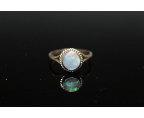 A HALLMARKED 18 CT WHITE GOLD OPAL RING,  in a simple rub over setting with rope twist border, ring size S 