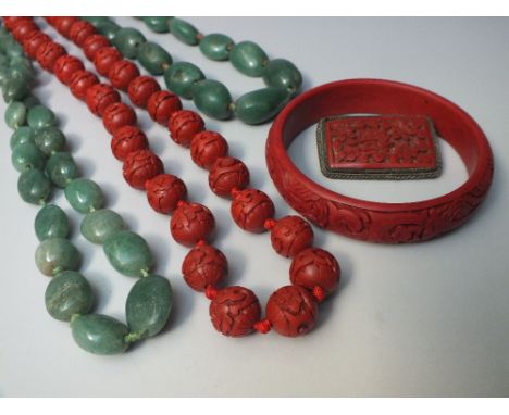 A COLLECTION OF CHINESE RED CINNABAR LACQUER JEWELLERY, consisting of a bangle, a carved bead necklace with yellow metal clas