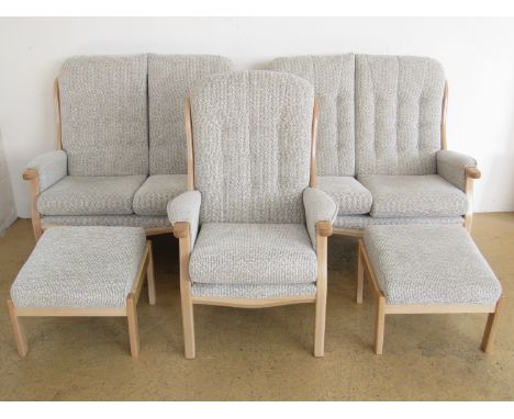 A five piece suite in light beech comprising two two-seater sofas, two footstools and an armchair, the suite being only 7 mon