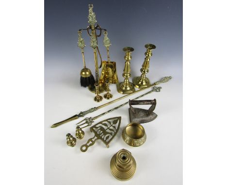An HMS Revenge brass companion set together with a poker, poker stand, toasting fork, two pairs of candlesticks and an iron a