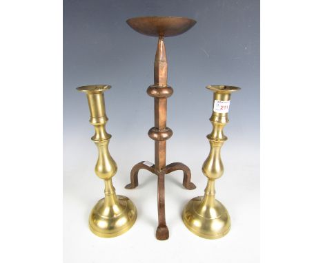 A pair of brass candlesticks together with one other large pricket candlestick