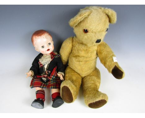 A vintage mohair Teddy bear with straw filled body and movable joints, together with a mid 20th Century moulded boy doll with