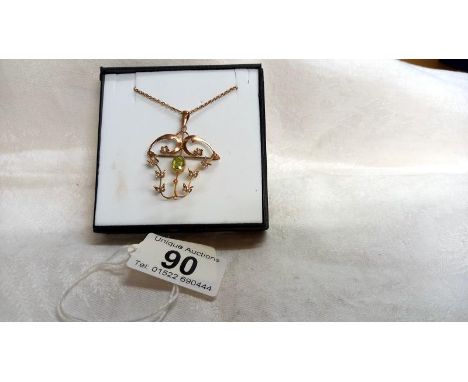 An Edwardian peridot and seed pearl pendant/brooch stamped 9ct in rose gold.