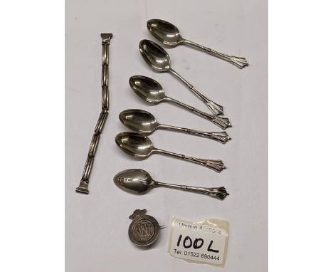 Six silver spoons, a silver badge and one other silver item 54.5 grams.