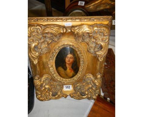 A gilt framed oval portrait of a lady.