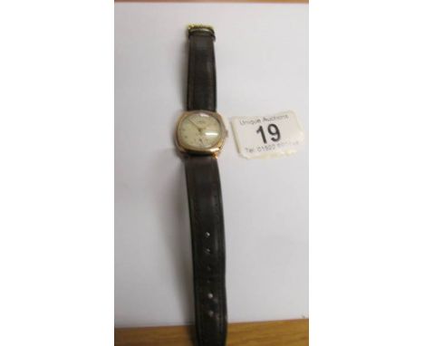 A Virtue 15 jewels manual wind in 9ct gold case, 29mm diameter, champagne dial, brown leather strap, in working order.