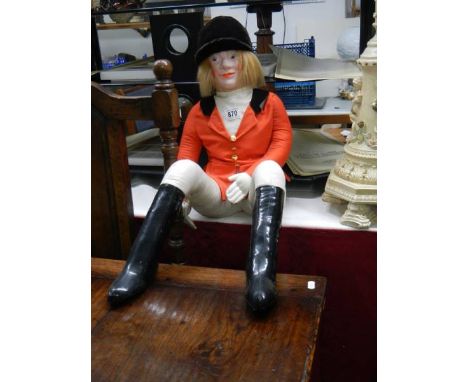 A vintage doll in hunting costume.