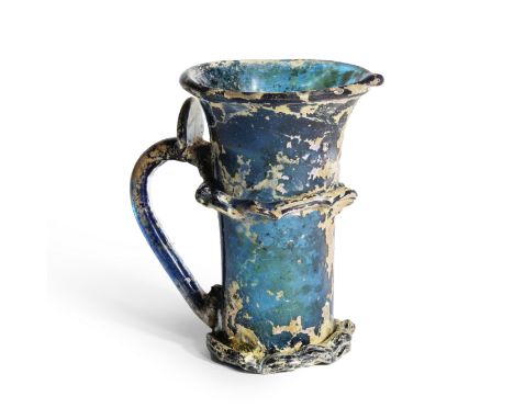 Tasse en verre composite bleu, Perse XIIe siècle A composite blue glass mug Persia, 12th Centuryof flared form with a vermicu