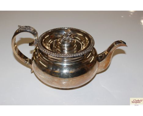 A silver teapot with floral finial, foliate decorated handle, marks indistinct, total weight 670gms 