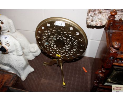 A brass trivet raised on tripod base 