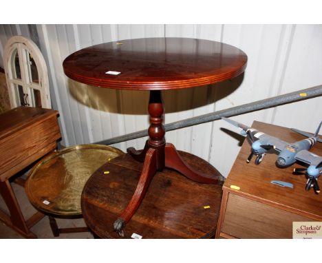 A reproduction mahogany circular topped table raised on tripod base