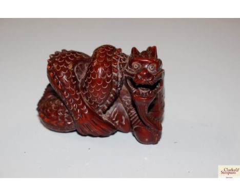 A wooden Netsuke in the form of a dragon, character mark to base 