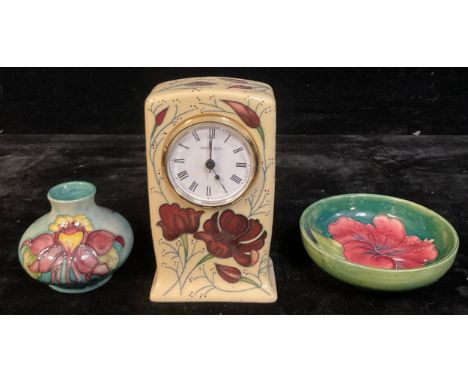 A Moorcroft mantel clock; a Moorcroft Hibiscus pattern trinket bowl; a Moorcroft vase (3) 