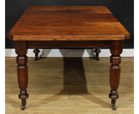 A late Victorian/Edwardian extending dining table, chamfered rectangular top with one additional leaf, turned legs, ceramic c