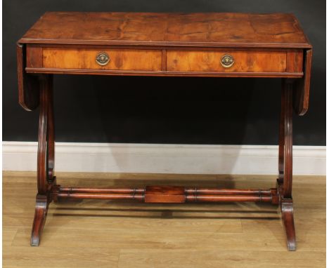 A Regency style yew veneer and mahogany sofa table, discorectangular top with fall leaves above a pair of frieze drawers, lyr