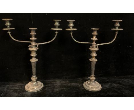 A pair of E.P.N.S three-light, two-branch table candelabra, campana sconces, detachable nozzles, reeded branches, tapered col