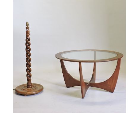 A 1970's teak circular coffee table, with a glass top, together with an oak spirally turned lamp