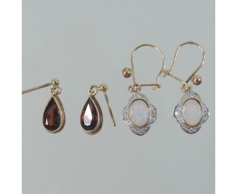 A pair of 9 carat gold garnet earrings, together with pair of 9 carat gold opal and diamond earrings, both boxed