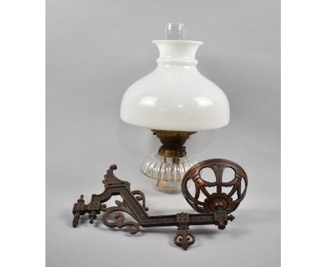 A Late Victorian Wall Hanging Oil Lamp with Glass Reservoir on Cast Iron Bracket 