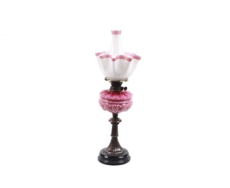 A Victorian Youngs Clissold oil lamp with satin pink reserve. With white and pink striped shade and funnel, all on a splayed 
