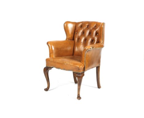An early 20th century tan leather button back armchair. With splayed arms, brass studs, raised on carved cabriole legs. H93cm