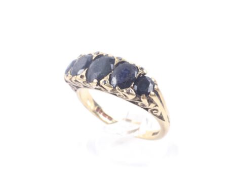 A vintage 18ct gold and sapphire five stone carved half-hoop ring with rose diamond points. The graduated oval dark blue sapp