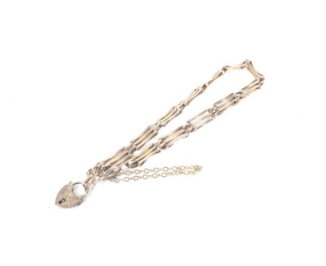An early 20th century rose gold three-bar gate bracelet. On a foliate engraved heart-shaped padlock clasp stamped '9ct', 5.6g