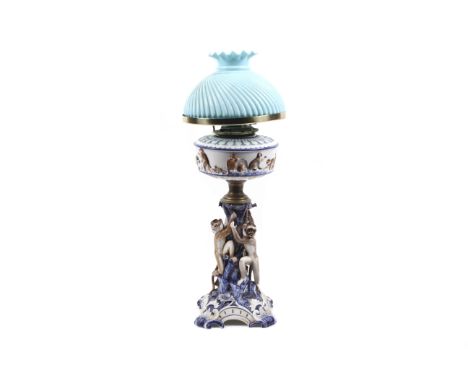 A late 19th century German porcelain oil lamp by Ernst, Bohne & Sohne decorated with monkeys. The reserve decorated with a co