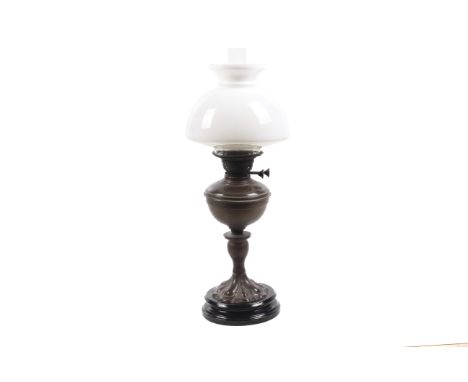 A late 19th/early 20th century oil lamp with white glass shade and clear chimney. The black lacquered base marked 'Veritas La