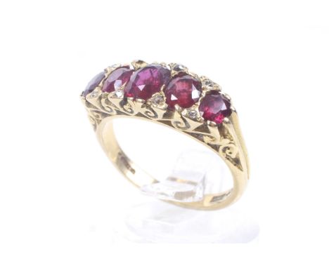 A vintage 18ct gold, ruby and diamond carved half-hoop ring in late Victorian style. Centred with a cushion-shaped ruby betwe