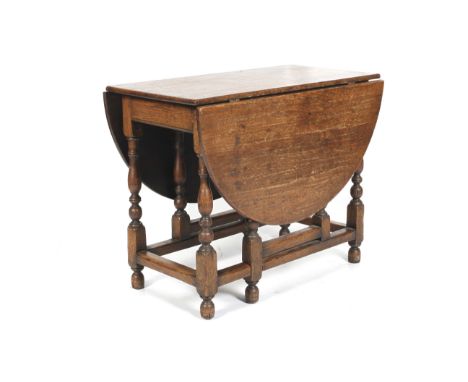 An 18th century oak gate leg oval table with turned vase-shaped uprights. H73cm x W91.5cm x L136cm (extended).