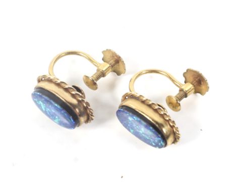 A pair of oval opal-doublet single stone screw earrings. Each black-ground opal-doublet measures approx. 11.5mm x 6.4mm, rub-