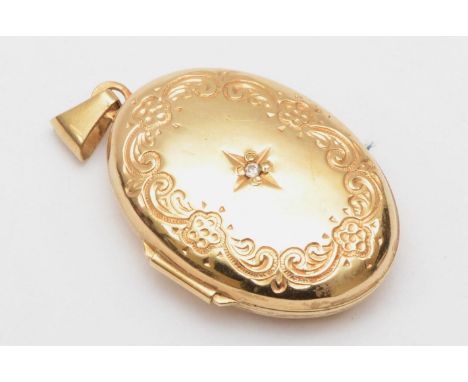 A 9ct gold oval locket with embossed scrolling detail centered with a small diamond, 3 x 2 cm, 3.3gm 