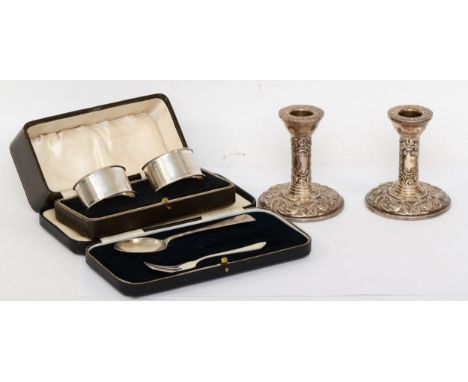 A George VI pair of silver napkin rings, Birmingham 1937, 48gm, cased, with a pair of silver candle sticks, Birmingham 1973, 