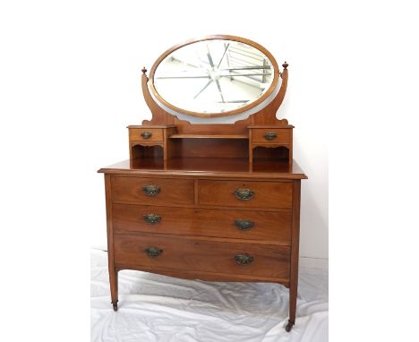 EDWARDIAN MAHOGANY DRESSING CHESTwith an oval bevelled swing mirror above two jewellery drawers and a recessed shelf, with tw