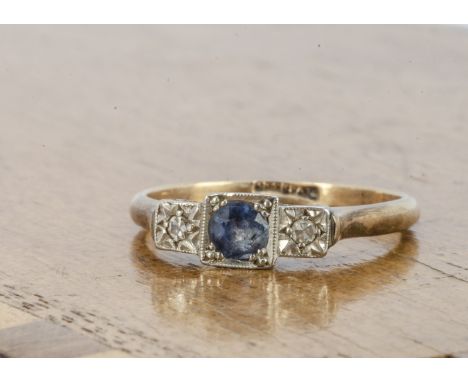 A three stone sapphire and diamond dress ring, the circular cut sapphire flanked by a pair of illusion set eight cut diamonds