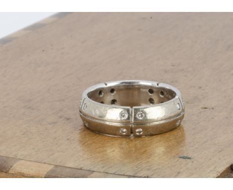 A continental white metal and diamond set band, the small brilliant cuts set in pairs to sectioned domed band marked 18k, rin