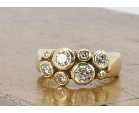 An 18ct gold diamond dress ring, in a modern cluster setting by Helen Brice, the brilliant cuts in collet setting with hallma