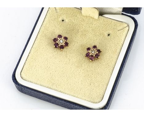 A pair of diamond and ruby studs, in yellow metal mounts and backs, cased 