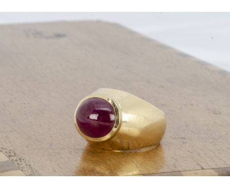 A continental gold and ruby lady's dress ring, the cabochon ruby in raised collar setting on a tapered yellow metal shank mar