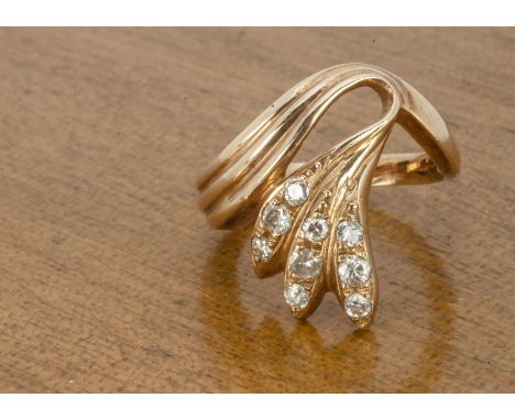 A contemporary diamond and yellow metal dress ring, the round cut diamonds in a leaf style setting marked 14k to inner shank,