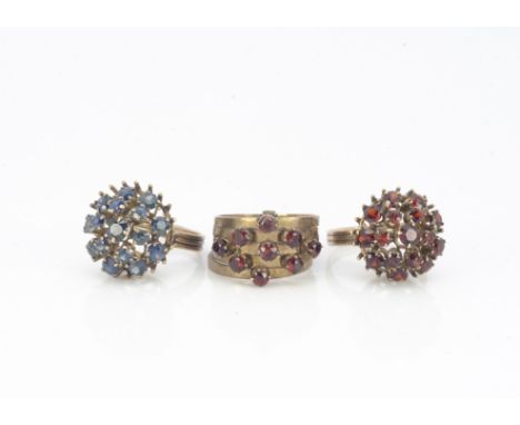 A Far Eastern sapphire domed cluster ring, ring size I, a garnet cluster ring, ring size K and another multi ring garnet dres
