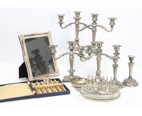 A collection of silver plate and other metal ware, including two candlesticks, a photograph frame, various flatware and much 