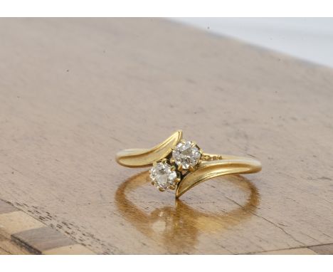 An 18ct gold diamond crossover dress ring, the old cut diamonds in claw settings, on a yellow hallmarked shank marked Birming