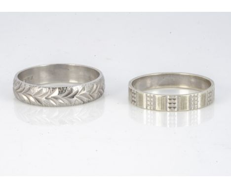 Two 9ct gold wedding bands, one with leaf design to textured base, ring size U, the other with engine turning, ring size R, 6