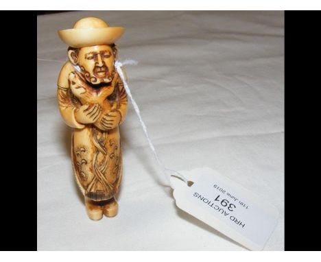 A carved ivory netsuke of Dutchman holding a puppy - possibly 18th century - 8.5cm high CONDITION REPORTas per images