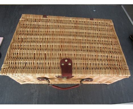A wicker four person picnic hamper, missing some items 