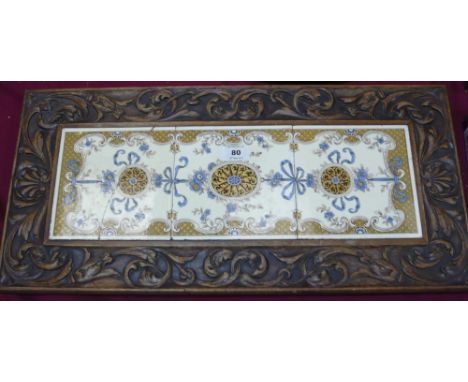 A carved pot stand on four squat feet with three central floral and swag tile decoration (tiles cracked)